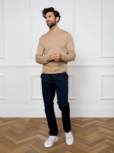 Man wearing light camel long sleeved crewneck sweater knit in 100% luxury and premium merino wool.